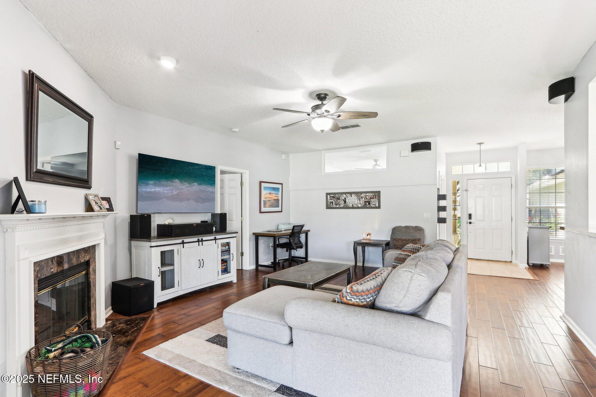 2124 Pond Spring Way Fleming Island, FL 32003 - Photo 7 of 56 a living room with furniture a flat screen tv and a fireplace