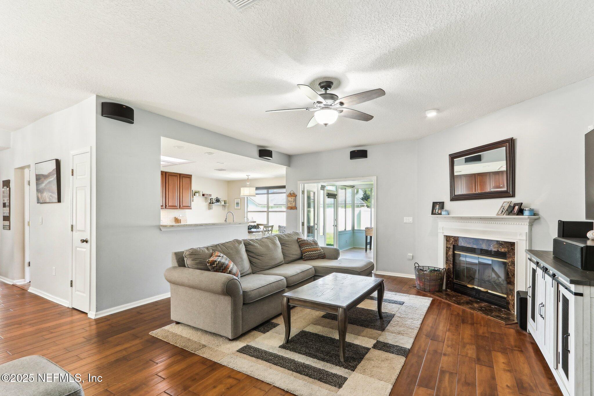 2124 Pond Spring Way Fleming Island, FL 32003 - Photo 8 of 56 a living room with furniture fireplace and a flat screen tv
