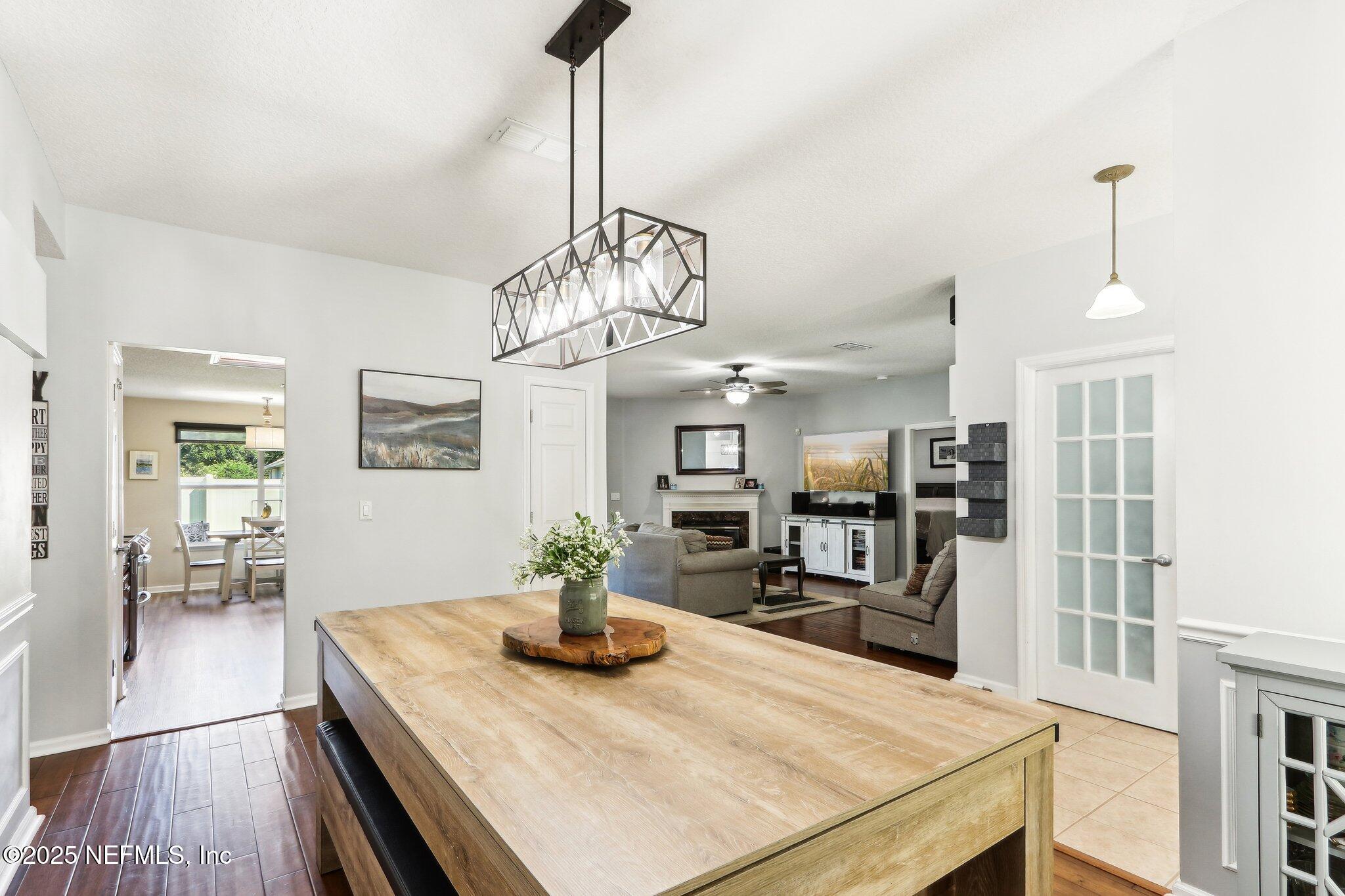 2124 Pond Spring Way Fleming Island, FL 32003 - Photo 10 of 56 a view of a dining room and livingroom with furniture wooden floor a chandelier