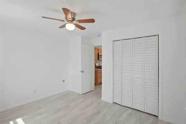 a view of a livingroom with wooden floor and a ceiling fan
