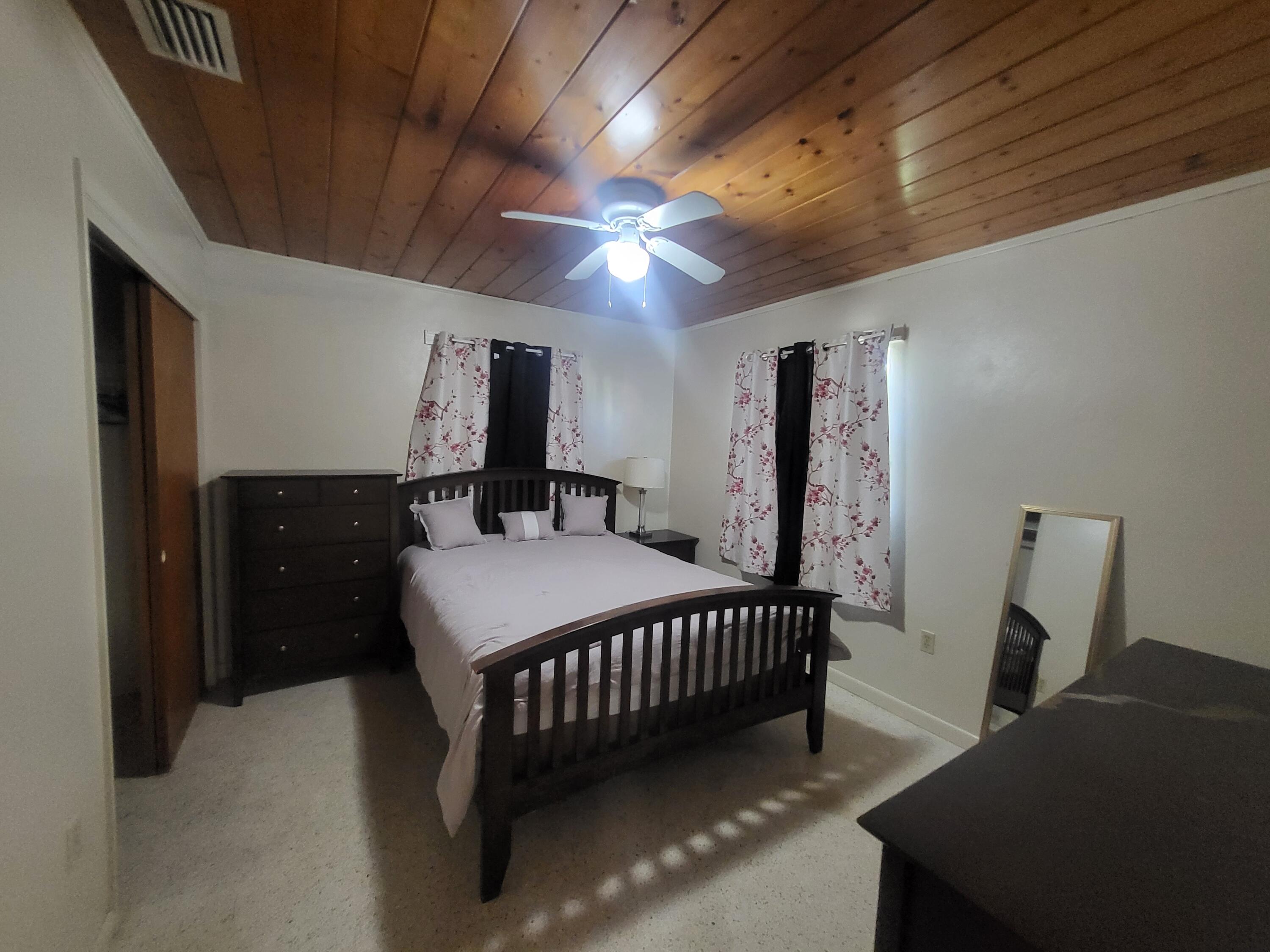 1169 Seaway Drive, Unit A Fort Pierce, FL 34949 - Photo 10 of 13 a bedroom with a bed and a mirror