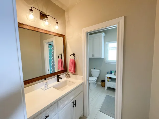 a en suite bathroom with a double vanity sink and a mirror