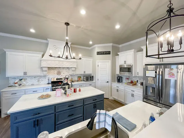 a kitchen with a sink a stove a refrigerator and cabinets