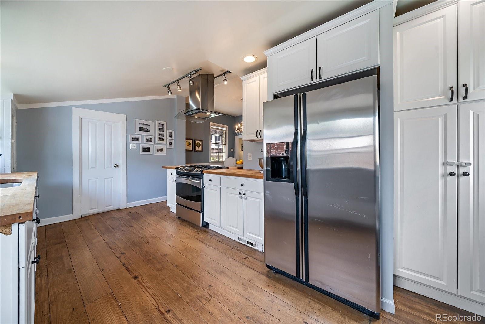 1776 South Logan Street Denver, CO 80210 - Photo 11 of 21 a kitchen with stainless steel appliances a refrigerator and a stove top oven