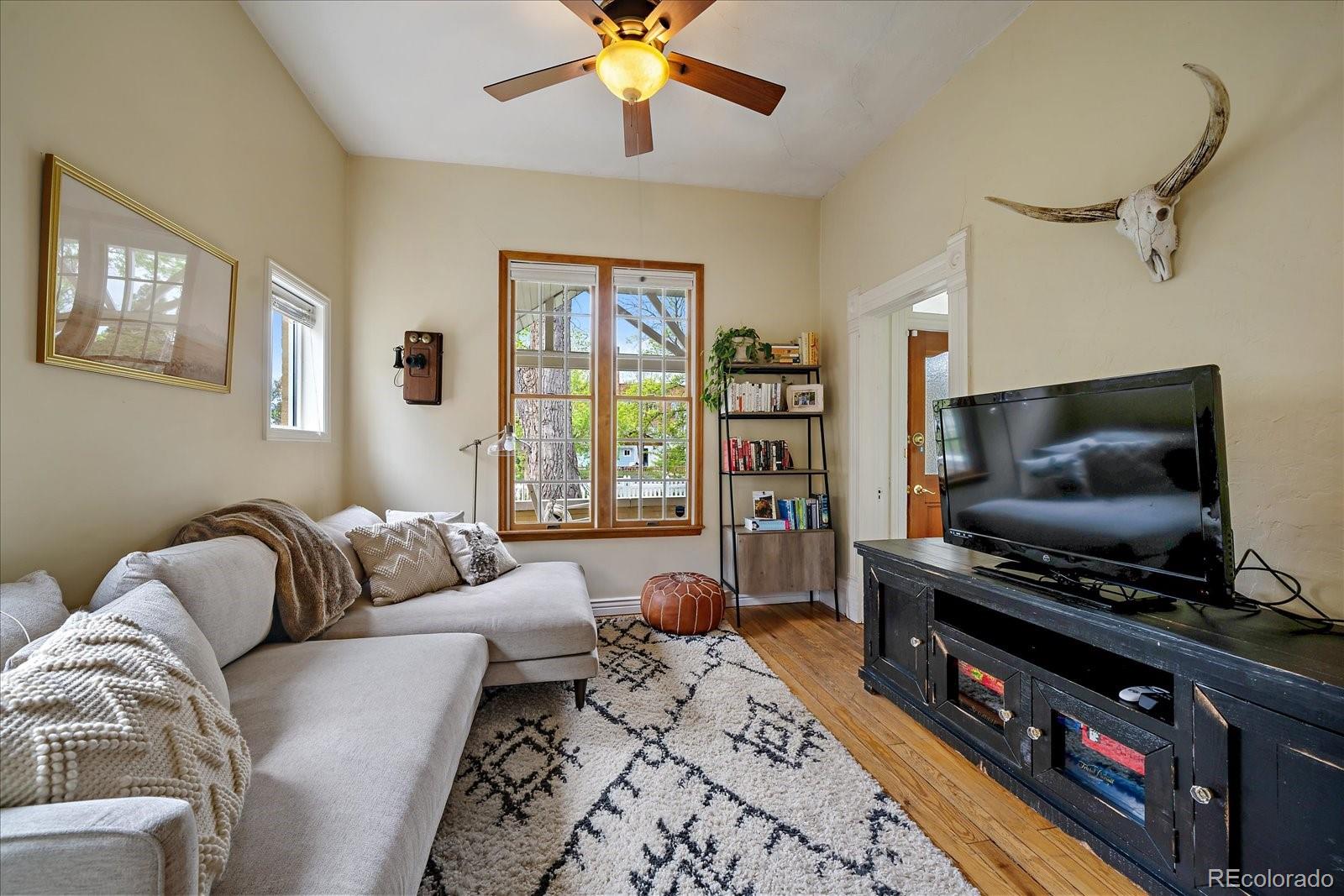 1776 South Logan Street Denver, CO 80210 - Photo 4 of 21 a living room with furniture and a flat screen tv