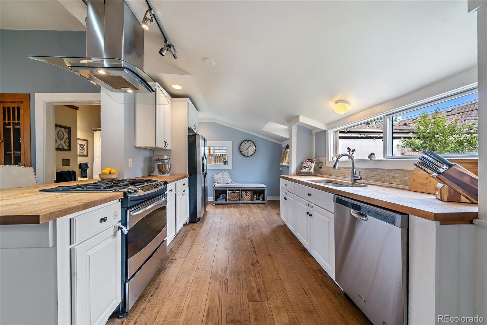 1776 South Logan Street Denver, CO 80210 - Photo 10 of 21 a large kitchen with stainless steel appliances granite countertop a lot of counter space and wooden floors