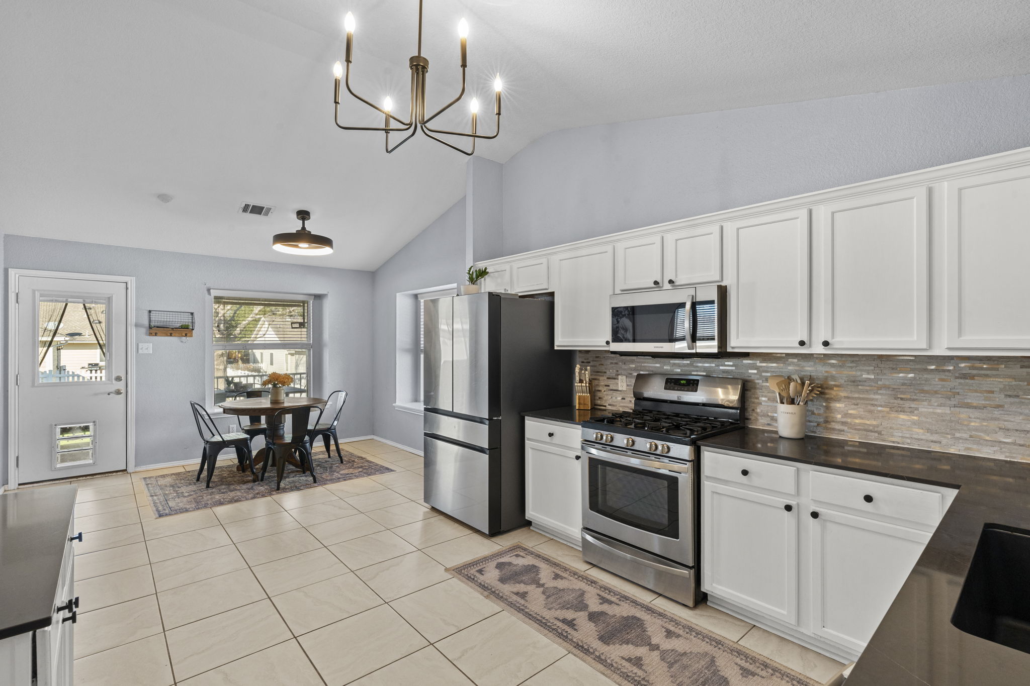 175 Wetzel Kyle, TX 78640 - Photo 6 of 40 Kitchen with stainless steel appliances, quartz countertops with single basin farmhouse sink updated faucet, white cabinets and high ceilings