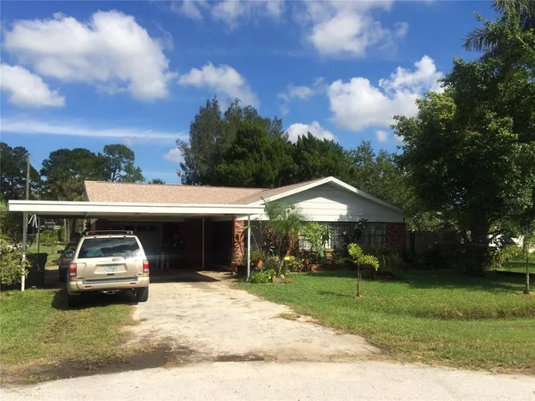a view of a car parked in front of a house with a yard