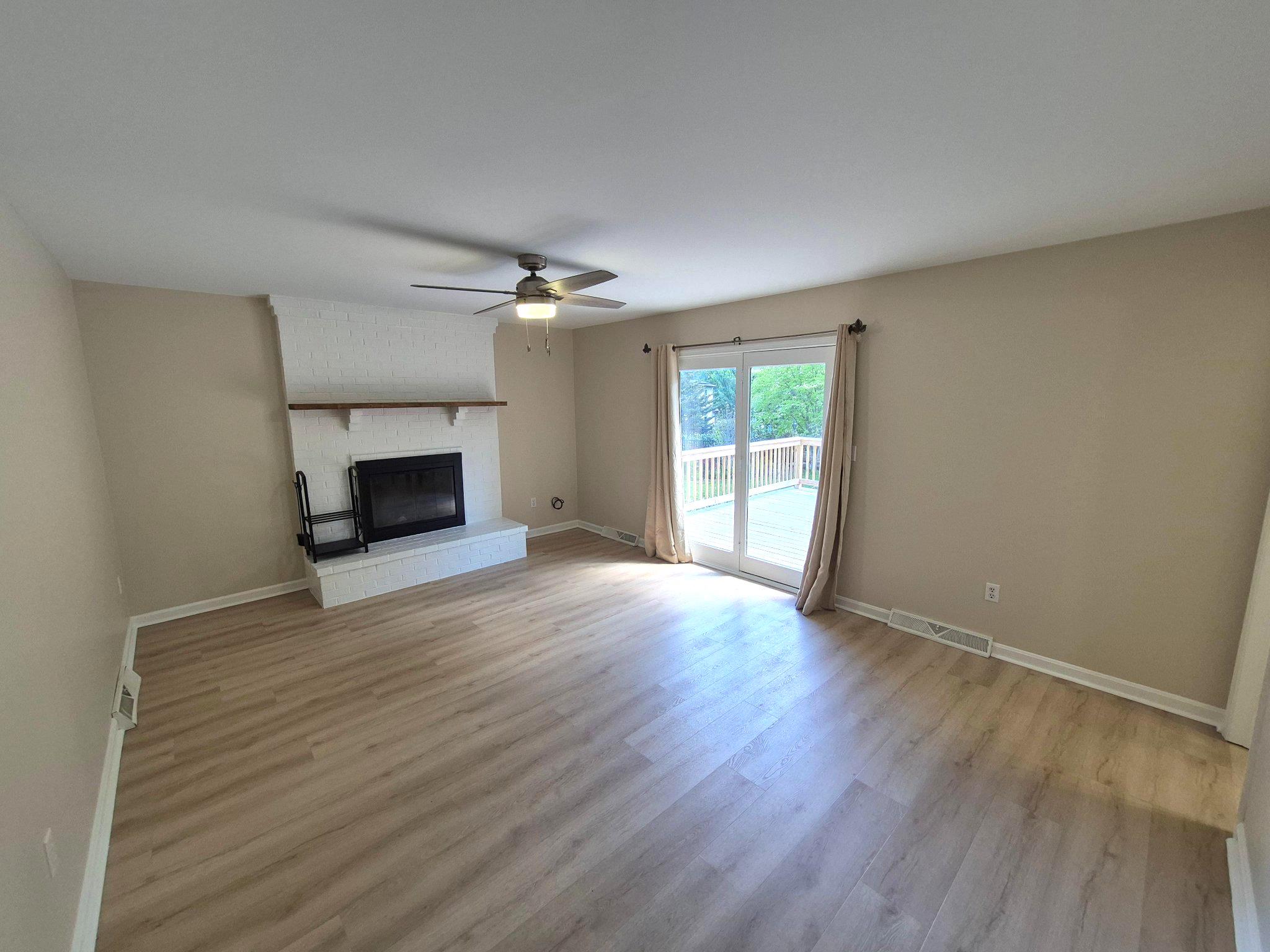 1406 Princeton Road Mechanicsburg, PA 17050 - Photo 26 of 53 an empty room with wooden floor fireplace and windows