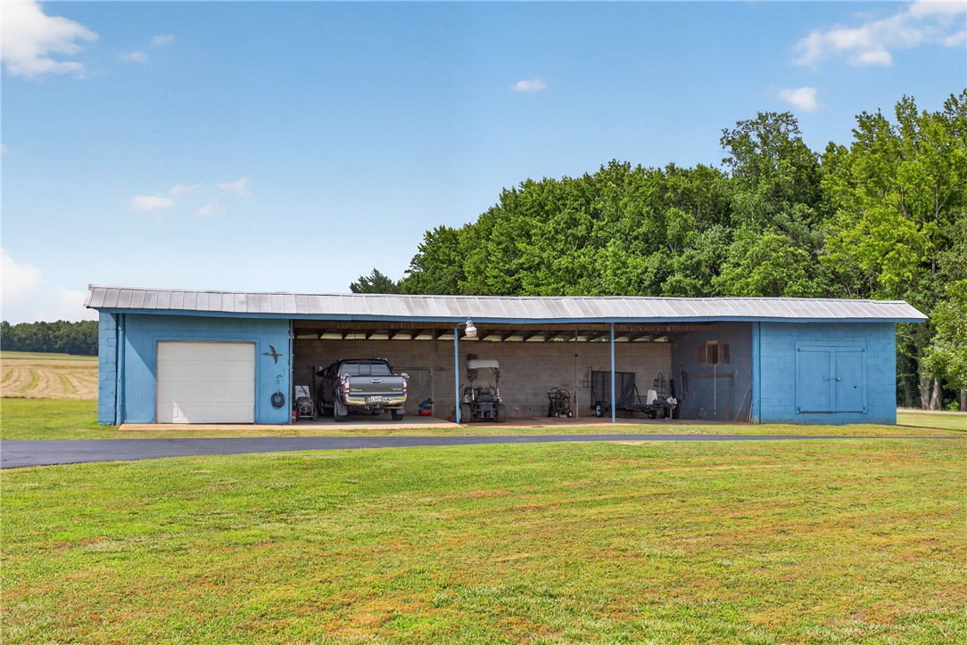 145 State Rd S-4-935 Pendleton, SC 29670 - Photo 29 of 47 A versatile outbuilding with covered parking and a secure garage offers ample storage solutions.