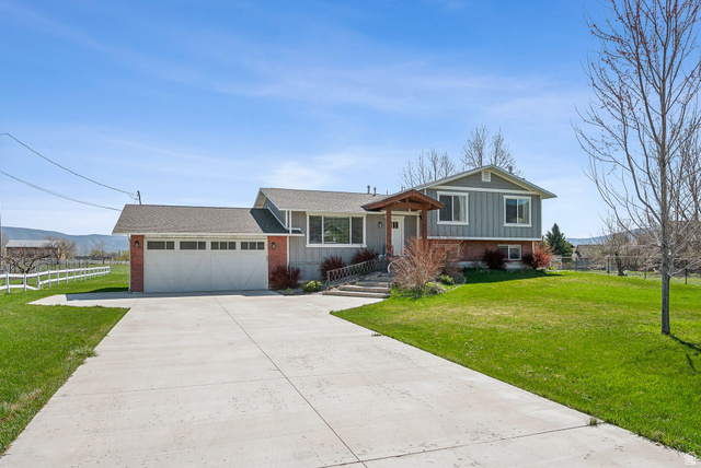 550 Pine Canyon Road Midway, UT 84049 - Photo 3 of 44 Split-level residence featuring a gray exterior with brick accents, an attached two-car garage, and a covered entry porch