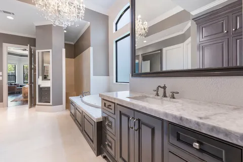a spacious bathroom with a granite countertop sink a mirror and a shower