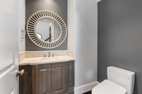 a bathroom with a toilet a sink and a mirror