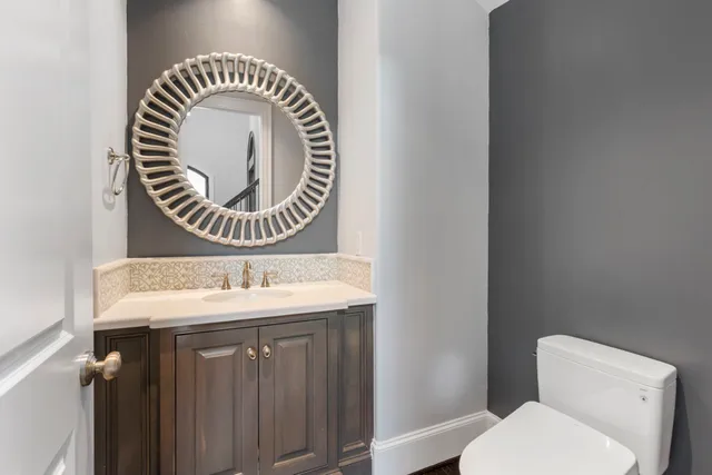 a bathroom with a toilet a sink and a mirror