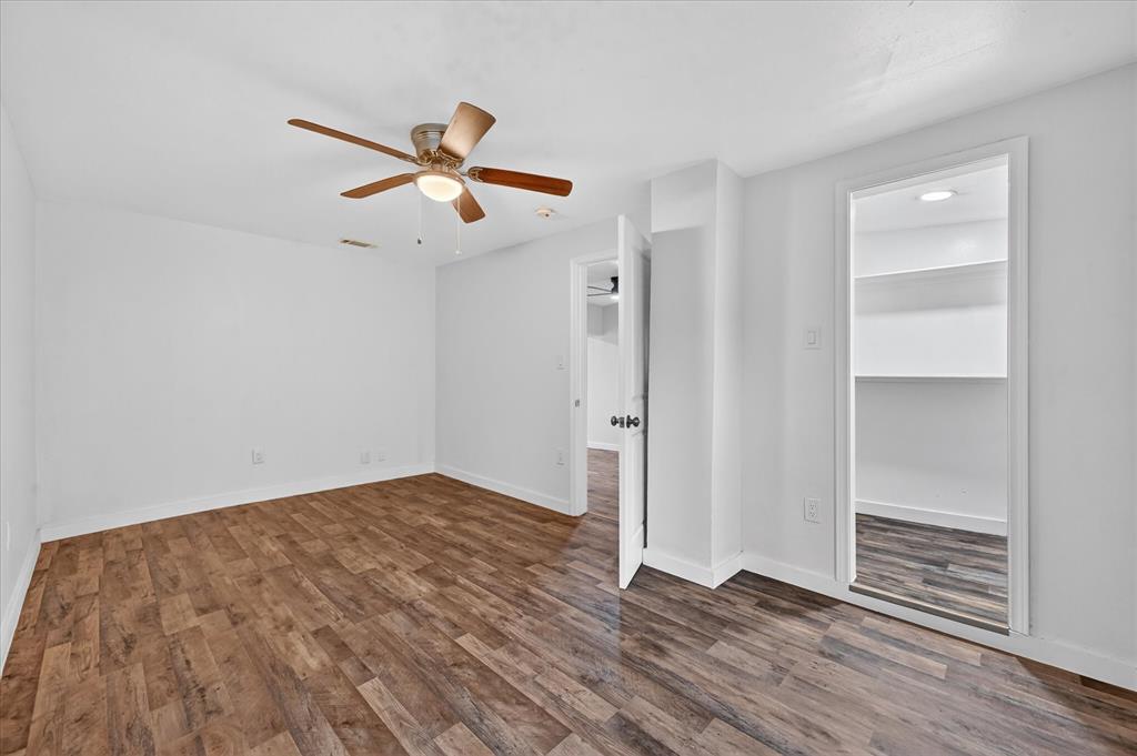 538 Pemberton Hill Road Dallas, TX 75217 - Photo 14 of 31 Spacious room featuring wood-finish flooring, crisp white walls, a ceiling fan with integrated lighting, and a walk-in closet with built-in shelving