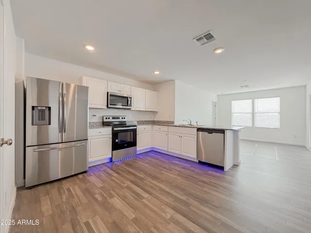 a kitchen with wooden floors and stainless steel appliances