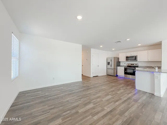 a view of kitchen with wooden floor and electronic appliances