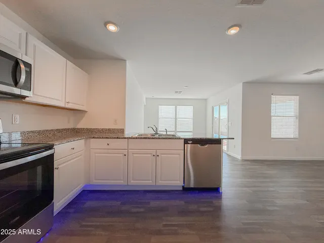 a kitchen with granite countertop white cabinets and white appliances