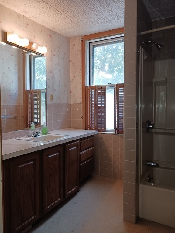 31 Orange Street Athol, MA 01331 - Photo 23 of 29 a bathroom with a double vanity sink a large mirror and a bathtub