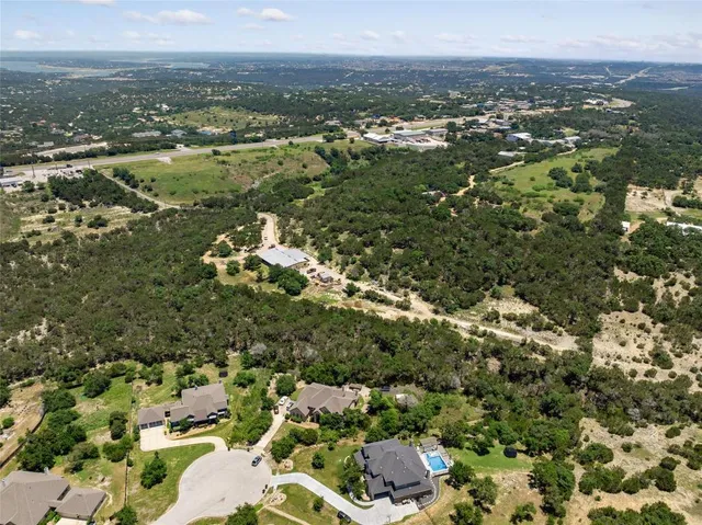 an aerial view of residential houses with outdoor space and trees