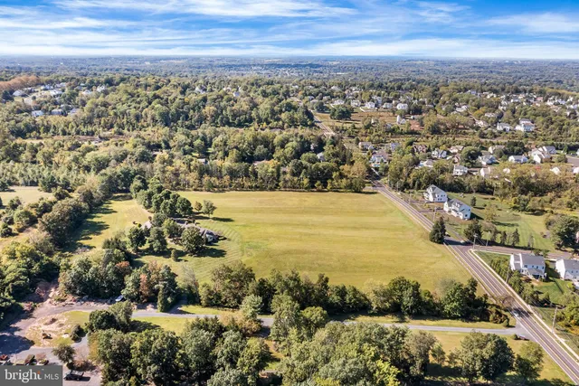 an aerial view of ocean and residential houses with outdoor space