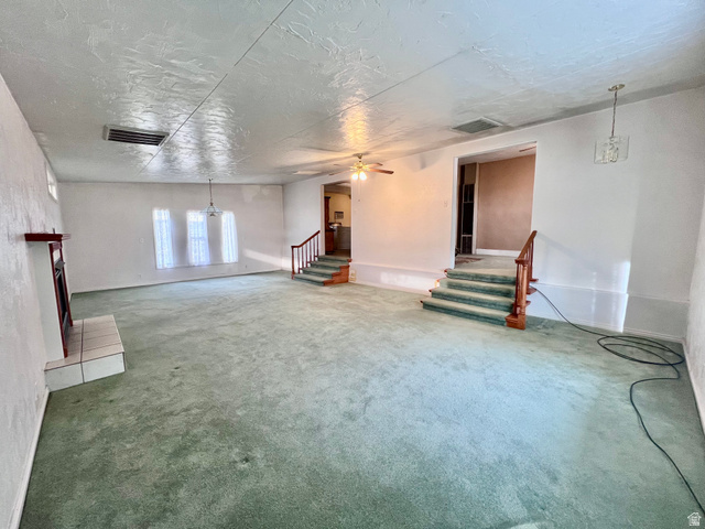 479 East 100 N Road Meadow, UT 84644 - Photo 5 of 59 Below grade area featuring a ceiling fan, a fireplace with raised hearth, carpet floors, a chandelier, and a textured ceiling
