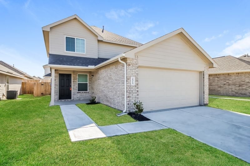 2515 Westslope Drive Conroe, TX 77384 - Photo 2 of 20 a front view of a house with a yard and garage