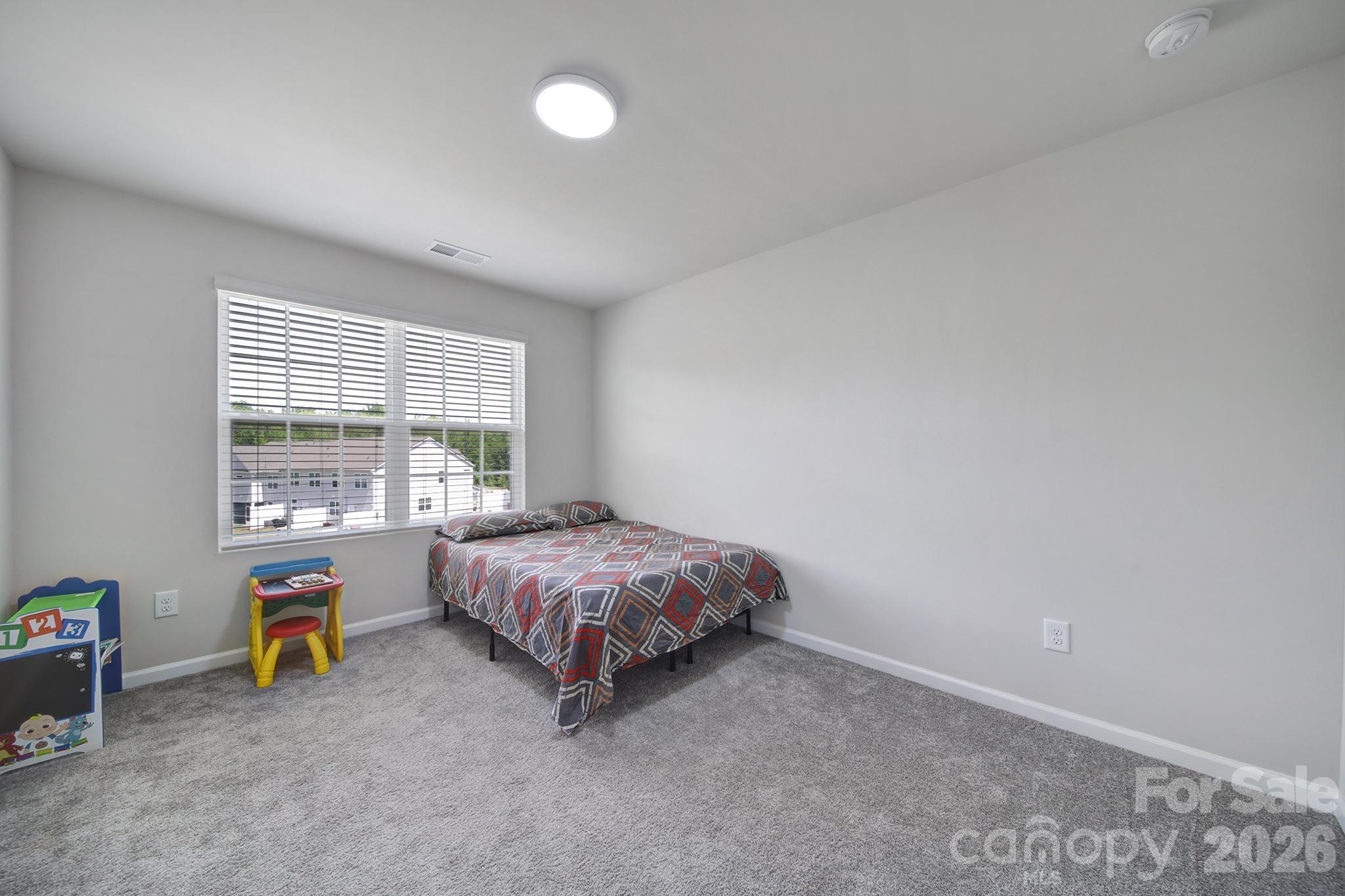 8042 Scarlet Maple Lane Fort Mill, SC 29708 - Photo 22 of 37 a spacious bedroom with a bed and a window