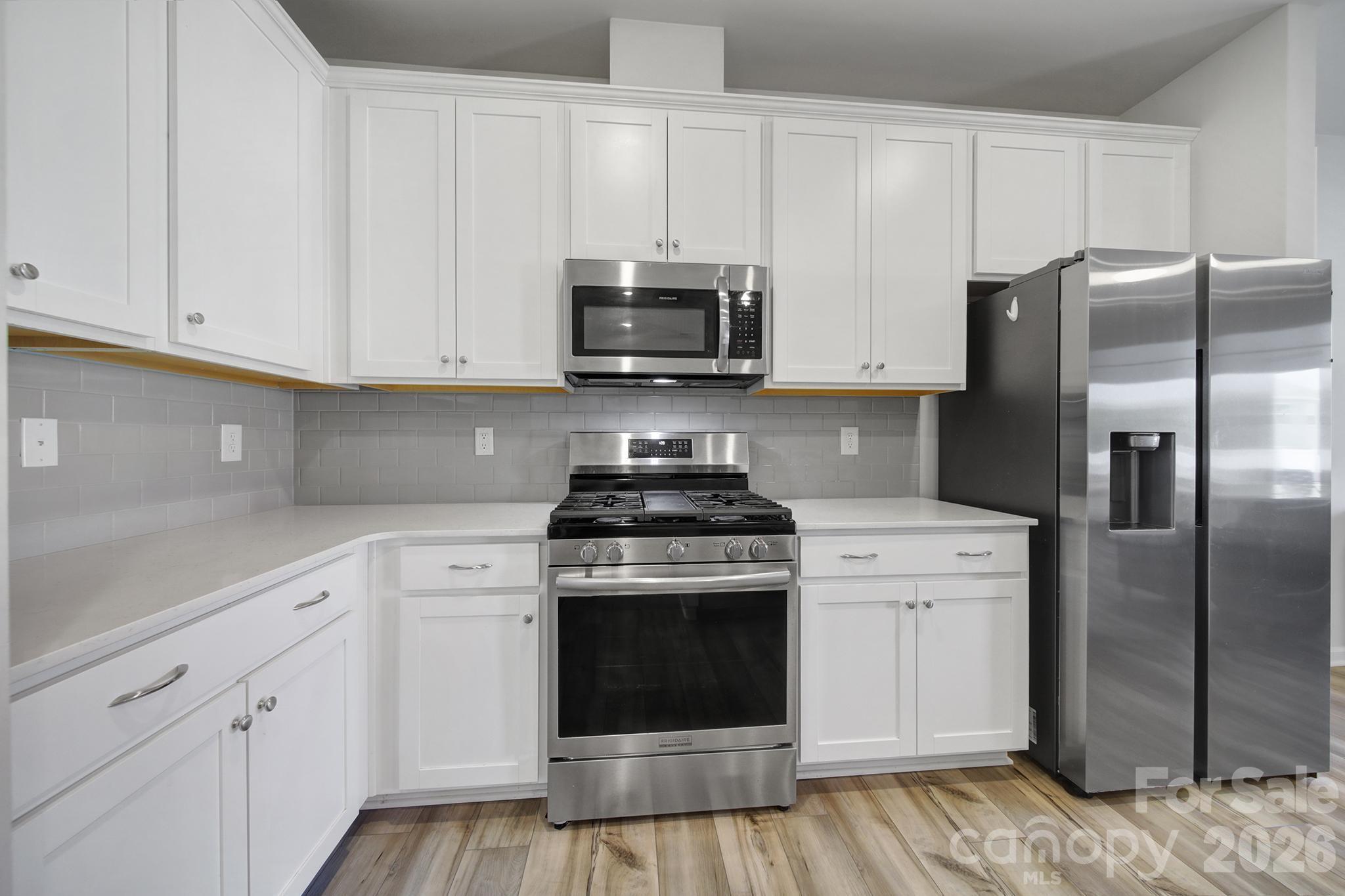 8042 Scarlet Maple Lane Fort Mill, SC 29708 - Photo 9 of 37 a kitchen with cabinets stainless steel appliances and wooden floor