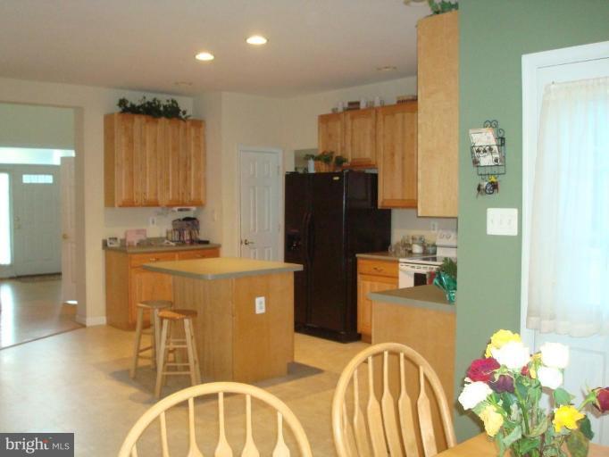 20115 Gunpowder Road Manchester, MD 21102 - Photo 27 of 29 a kitchen with granite countertop a refrigerator a stove a sink a dining table and chairs with wooden floor