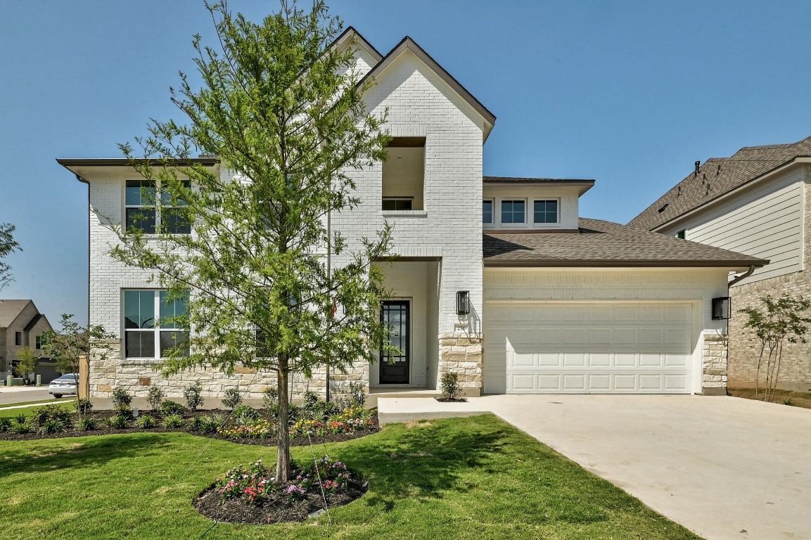 a front view of a house with a yard and garage