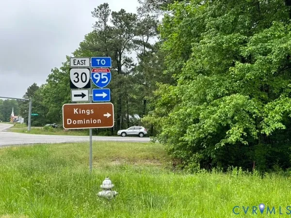 a sign that is sitting in the grass next to a road