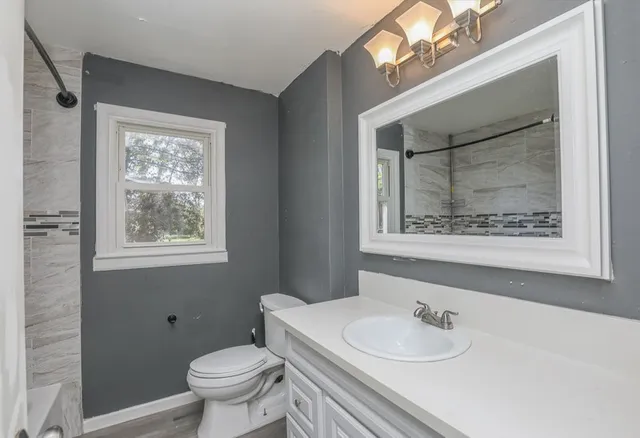 a bathroom with a toilet sink and mirror