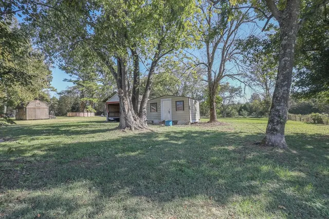 a view of a house with yard and a tree