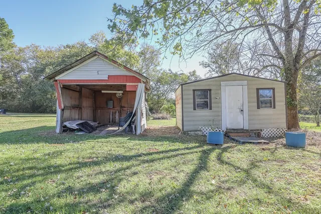 a view of a house with a yard and large tree