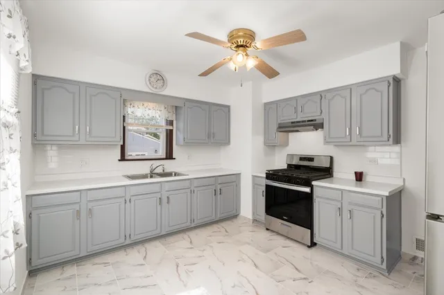 a kitchen with stainless steel appliances granite countertop a refrigerator a stove and a sink