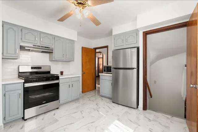 a kitchen with a refrigerator and a stove top oven