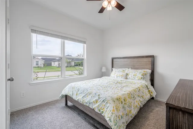 a bedroom with a bed lamp and window