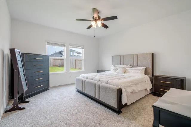 a bedroom with a bed and a ceiling fan