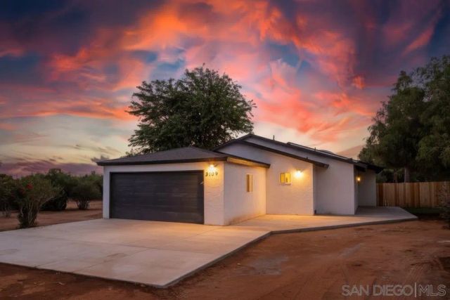 a front view of a house with a garage and a yard