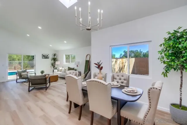 a kitchen with a sink a stove a refrigerator and white cabinets with wooden floor