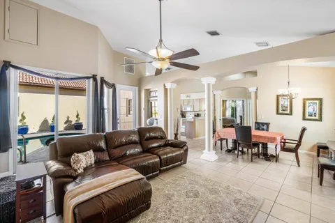 a living room with furniture a large window and a chandelier