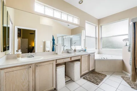 a bathroom with a sink vanity tub shower and a mirror
