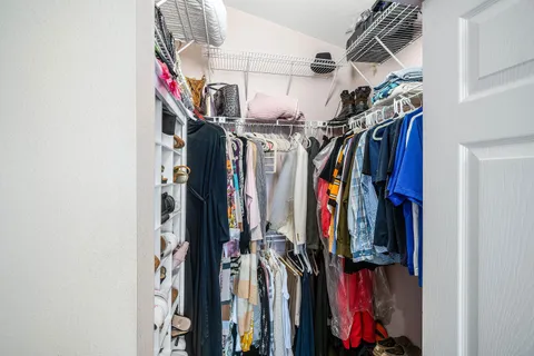 a view of walk in closet with clothes