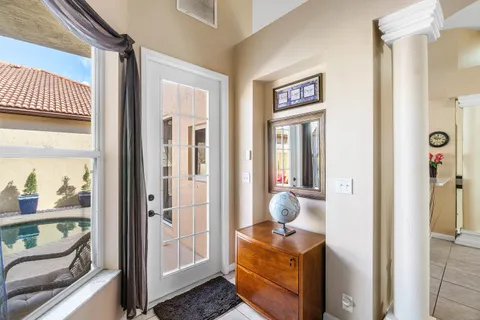 a view of a hallway and a livingroom with wooden floor and windows