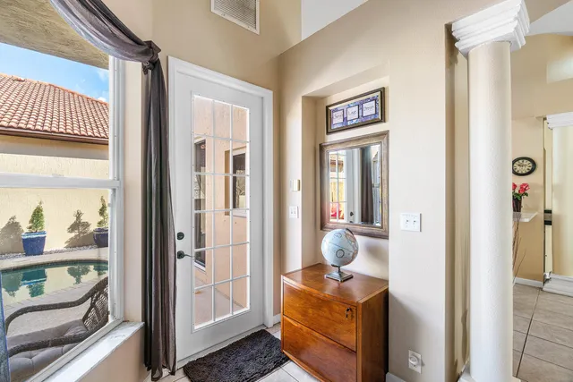 a view of a hallway and a livingroom with wooden floor and windows