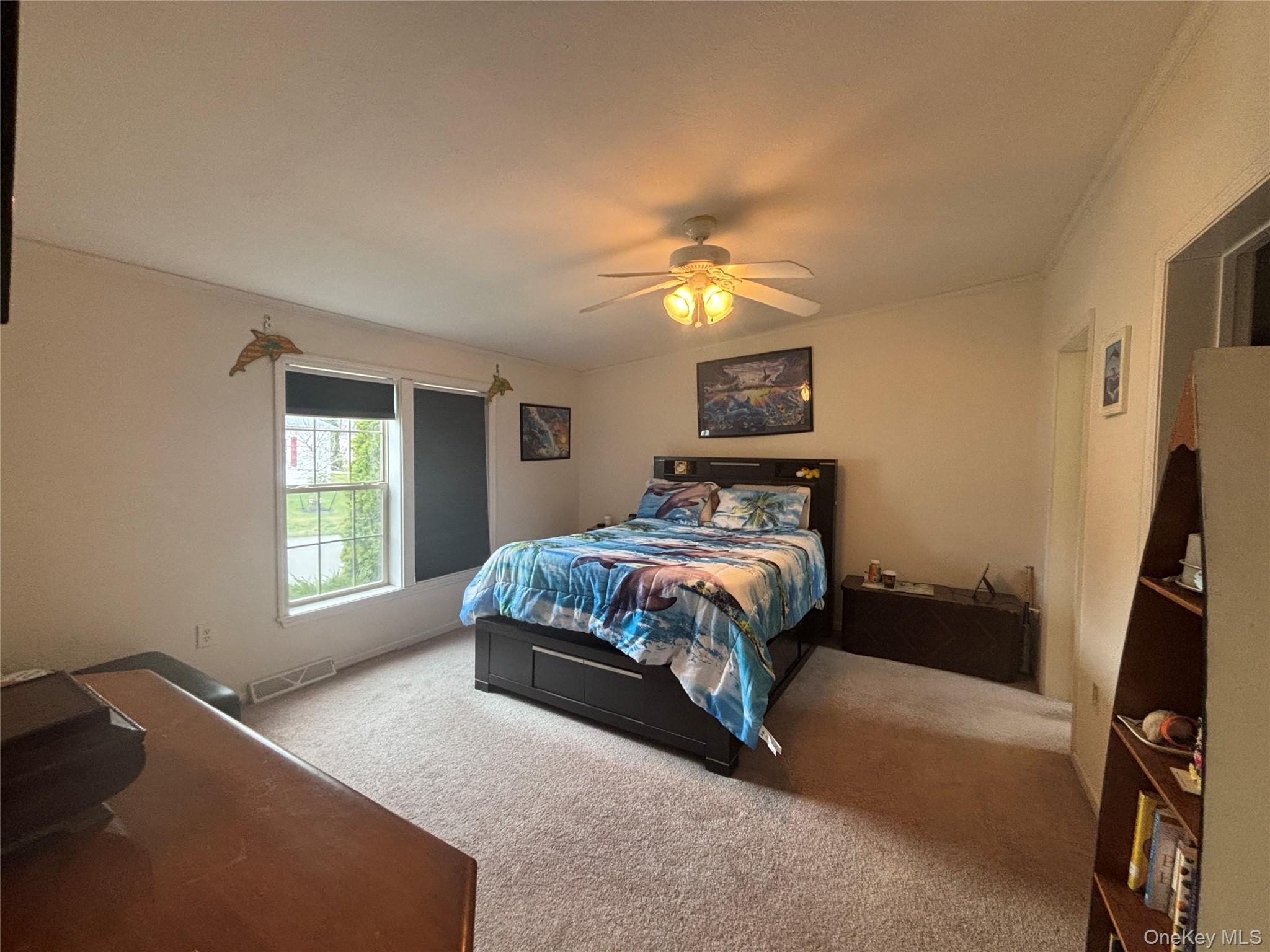 1661 Old Country Road, Unit 417 Riverhead, NY 11901 - Photo 13 of 20 a bedroom with a bed next to a window and a flat screen tv