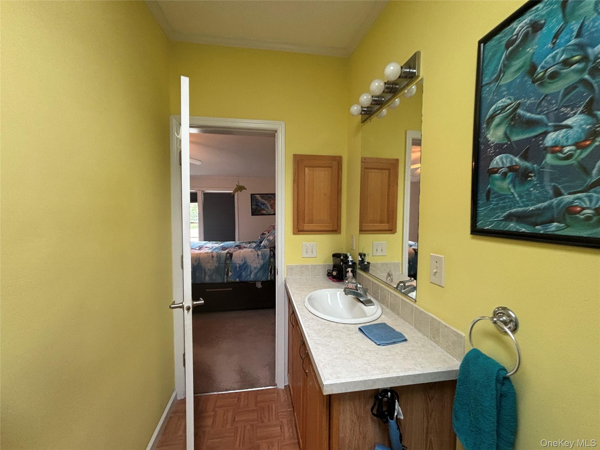1661 Old Country Road, Unit 417 Riverhead, NY 11901 - Photo 15 of 20 a en suite bathroom with a sink and a mirror