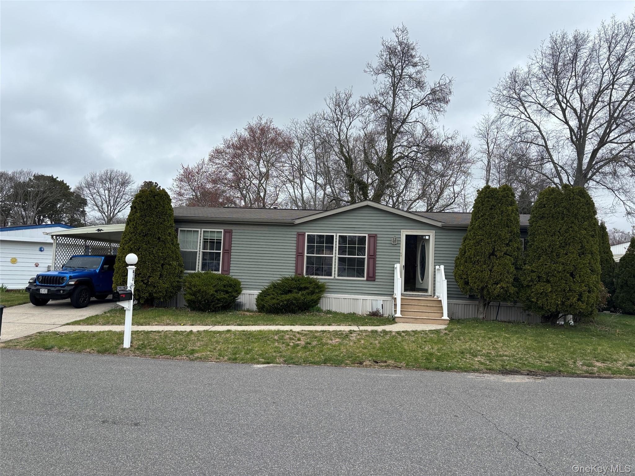 1661 Old Country Road, Unit 417 Riverhead, NY 11901 - Photo 2 of 20 a front view of a house with a yard and garage