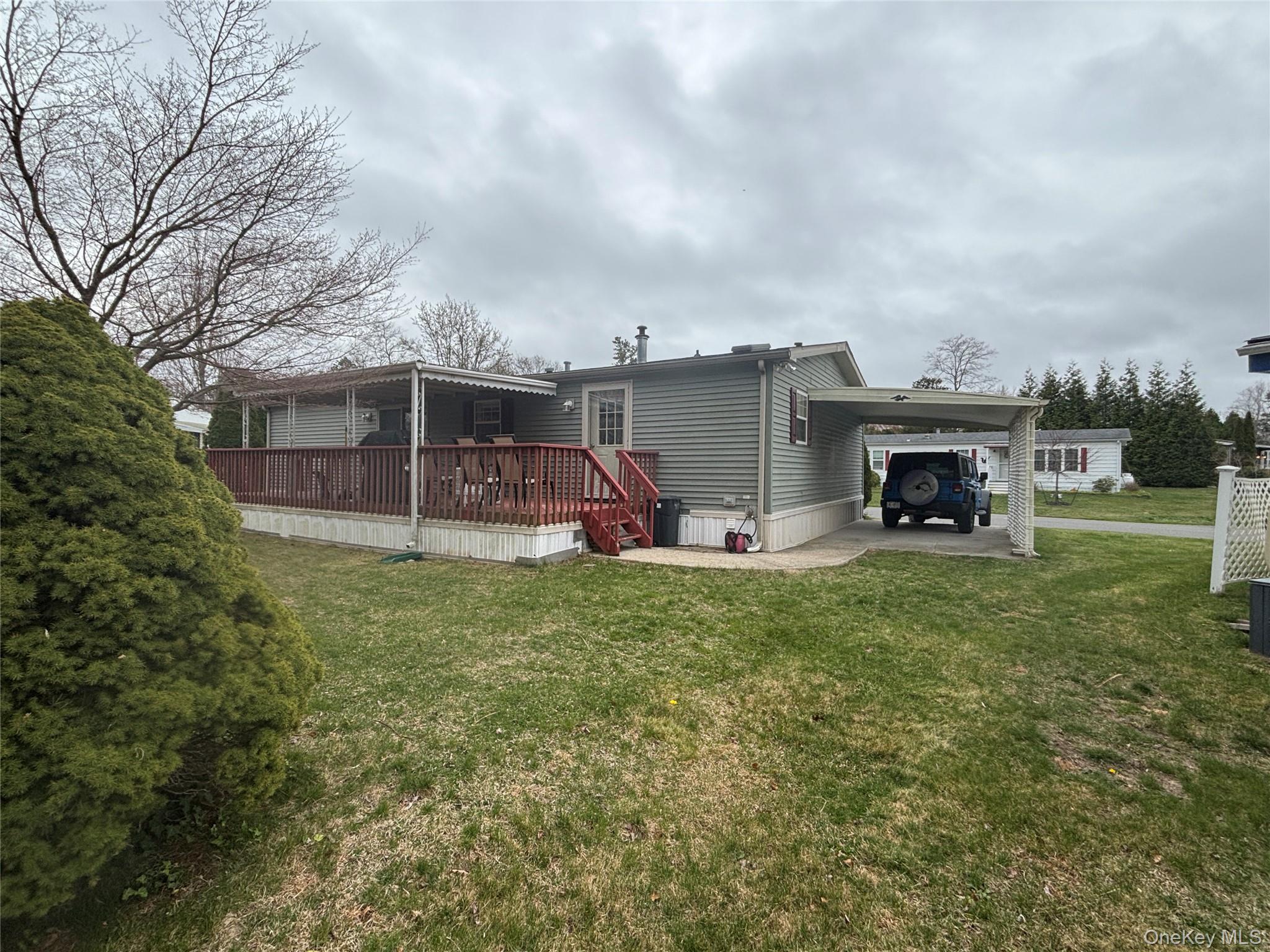 1661 Old Country Road, Unit 417 Riverhead, NY 11901 - Photo 3 of 20 a view of a house with a backyard and a garden